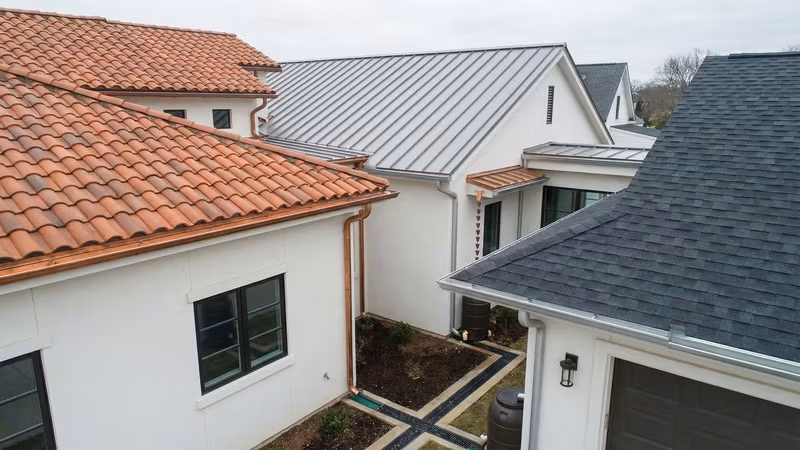 Diferentes tipos de telhados com sistemas de calhas e drenagem