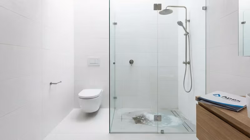 Banheiro moderno com vaso sanitário e chuveiro mostrando problema de drenagem